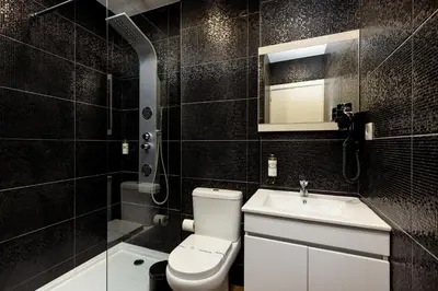a black tiled bathroom with a toilet and a sink at Feel Porto Wine Essence Apartments in Vila Nova de Gaia