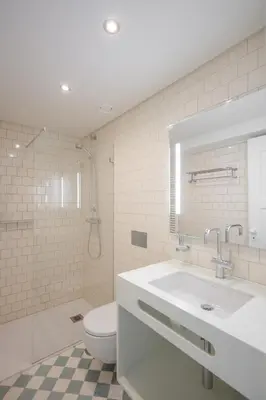 a bathroom with a sink and a toilet and a mirror at Menina Colina Guesthouse in Porto