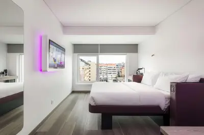 a hotel room with a large bed and a window at YOTEL Porto in Porto