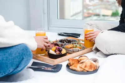 two people sitting on the floor with a tray of food and drinks at YOTEL Porto in Porto