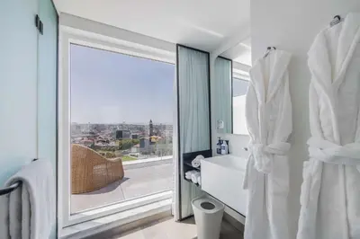 a bathroom with a tub and a window with a view at YOTEL Porto in Porto