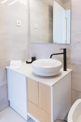 a white bathroom with a sink and a mirror at Aposentus - Skyline Porto in Porto