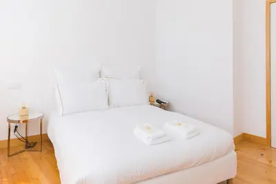 a white bed with two white towels on it at Aposentus - Skyline Porto in Porto