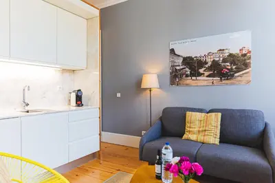 a living room with a blue couch and a table at APOSENTUS - Your Home at Oliveiras in Porto