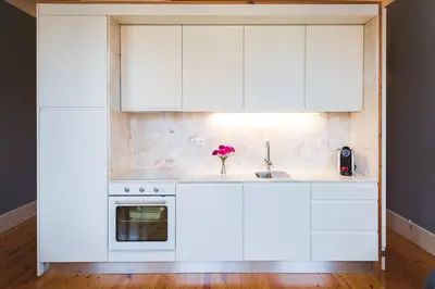 a kitchen with white cabinets and a sink at APOSENTUS - Your Home at Oliveiras in Porto