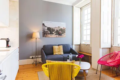 a living room with a blue couch and a table at APOSENTUS - Your Home at Oliveiras in Porto