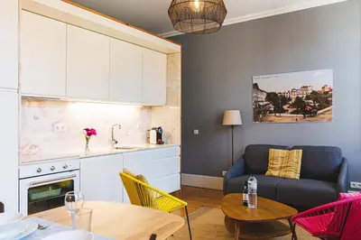 a kitchen and a living room with a couch and a table at APOSENTUS - Your Home at Oliveiras in Porto