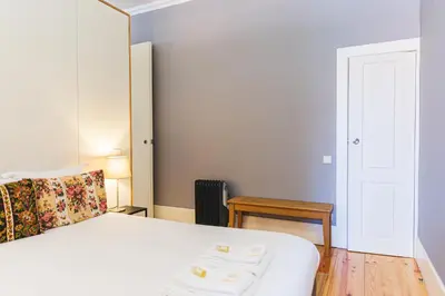 a bedroom with a bed and a table and a door at APOSENTUS - Your Home at Oliveiras in Porto
