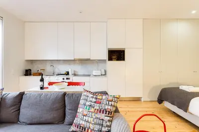 a living room with a couch and a kitchen at Pinheiro Terrace Downtown Apartment by DA'HOME in Porto