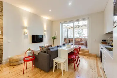 a kitchen and living room with a couch and a table at Pinheiro Terrace Downtown Apartment by DA'HOME in Porto