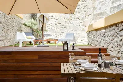 a restaurant with a table and chairs and an umbrella at Pinheiro Terrace Downtown Apartment by DA'HOME in Porto