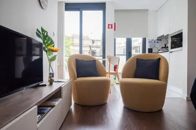 a living room with two chairs and a television at Sunflower Luxury Loft w AC Downtown and Metro in Porto