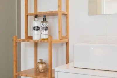 a shelf with three bottles of wine on it next to a refrigerator at Sunflower Luxury Loft w AC Downtown and Metro in Porto