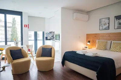 a bedroom with a bed and two chairs at Sunflower Luxury Loft w AC Downtown and Metro in Porto