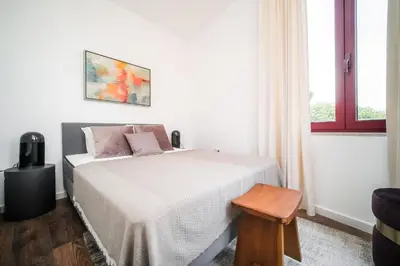 a white bedroom with a bed and a window at Nomad's Fine Arts Collection in Porto