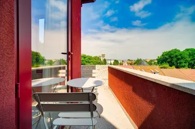 a balcony with tables and chairs on a red wall at Nomad's Fine Arts Collection in Porto