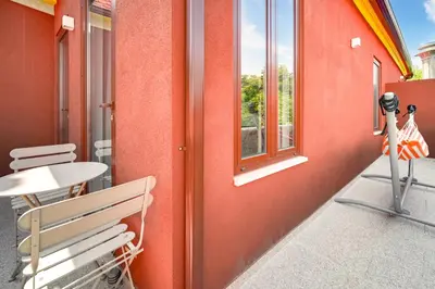 a red wall with a bench and a window at Nomad's Fine Arts Collection in Porto