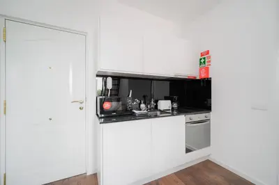 a kitchen with white cabinets and a counter top at Nomad's Fine Arts Collection in Porto