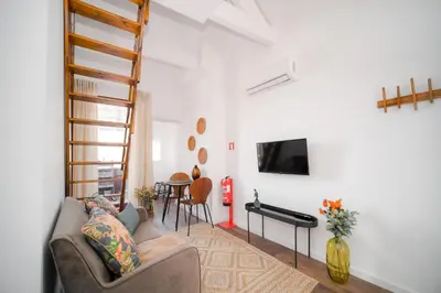 a living room with a couch and a tv at Nomad's Fine Arts Collection in Porto
