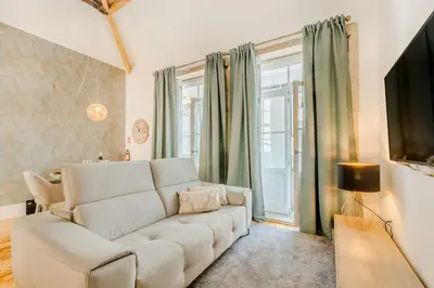 a green vase with branches in it on a table at Santa Catarina Charming Loft in Porto