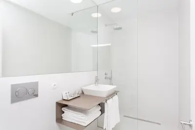 a white bathroom with a sink and a shower at S.Bento Residences in Porto