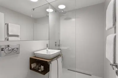 a white bathroom with a sink and a shower at S.Bento Residences in Porto