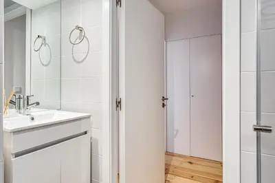 a white bathroom with a sink and a shower at Hopstays Oporto Tiles 2 - City Center Duplex in Porto