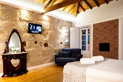 a bedroom with a bed and a chair and a mirror at Old City Oporto in Porto