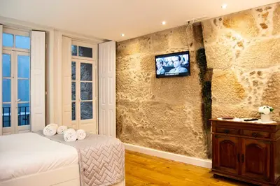 a bedroom with a bed and a tv on a wall at Old City Oporto in Porto