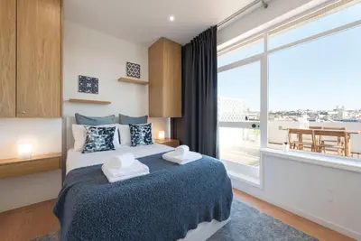 a bedroom with a bed and a large window at Oporto Dinis Apartment - Rooftop in Porto
