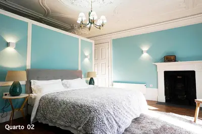 a bedroom with a bed with blue walls and a fireplace at Santa Catarina Guest House (Porto city center) in Porto
