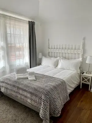 a white bedroom with a large bed and a window at Santa Catarina Guest House (Porto city center) in Porto