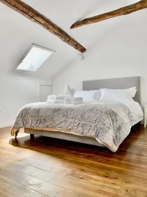 a white bedroom with a large bed with wooden floors at Santa Catarina Guest House (Porto city center) in Porto