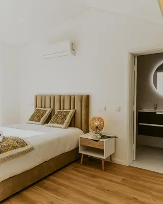 a bedroom with a large bed and a table at Bruval Premium Apartments - Gaia in Vila Nova de Gaia