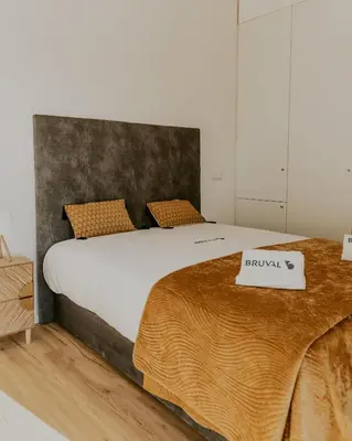 a bedroom with a large bed with a blanket on it at Bruval Premium Apartments - Gaia in Vila Nova de Gaia