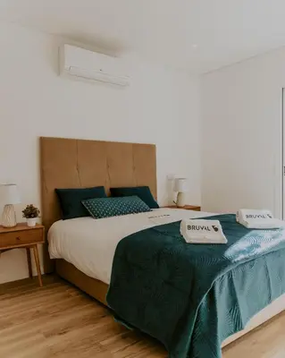 a bedroom with a large bed with blue and green sheets at Bruval Premium Apartments - Gaia in Vila Nova de Gaia