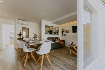 a dining room and living room with a table and chairs at Bruval Premium Apartments - Gaia in Vila Nova de Gaia