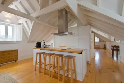 a kitchen with a counter and stools in a room at APOSENTUS - Architect and design apartment in Porto