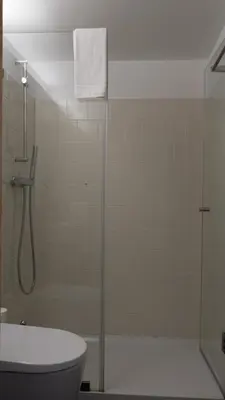 a bathroom with a shower with a toilet and a sink at APOSENTUS - Architect and design apartment in Porto