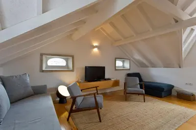 a living room with a couch and a tv at APOSENTUS - Architect and design apartment in Porto