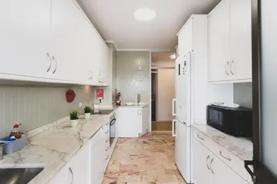 a kitchen with white cabinets and marble counter tops at APOSENTUS - Elegant Functionality Porto Downtown in Porto