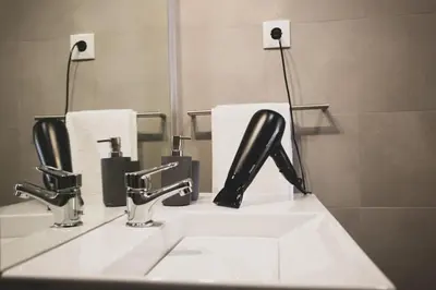 a bathroom with a sink and two faucets and towels at APOSENTUS - Elegant Functionality Porto Downtown in Porto