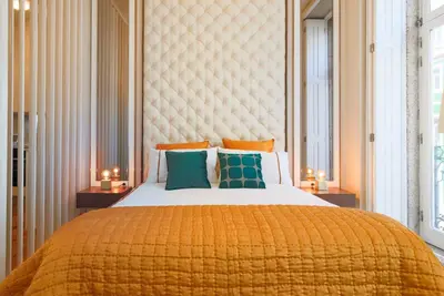 a bedroom with a large bed with a yellow blanket at Esmeralda Apartment by Cozy Stay in Porto