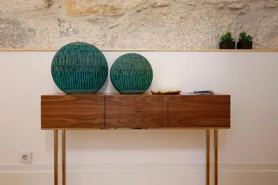 two green plates sitting on top of a wooden table at Esmeralda Apartment by Cozy Stay in Porto