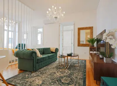 a living room with a green couch and a table at Esmeralda Apartment by Cozy Stay in Porto