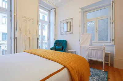 a bedroom with a bed and a blue chair at Esmeralda Apartment by Cozy Stay in Porto