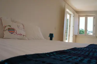 a bedroom with a bed with a pillow and a window at Alfandega Apartments in Porto
