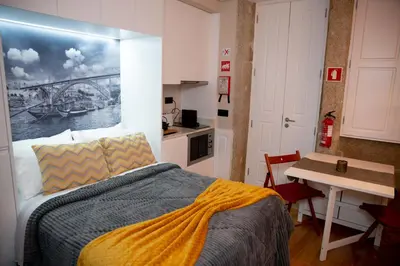 a bedroom with a bed with a painting on the wall at lita’s House Oporto Bainharia in Porto