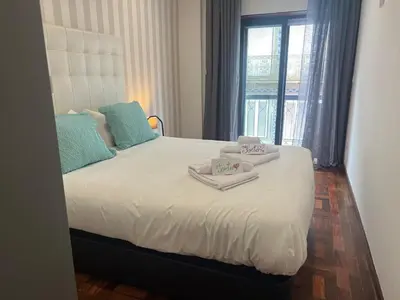 a bedroom with a bed with two towels on it at OPORTO APARTMENT LUXURY in Porto
