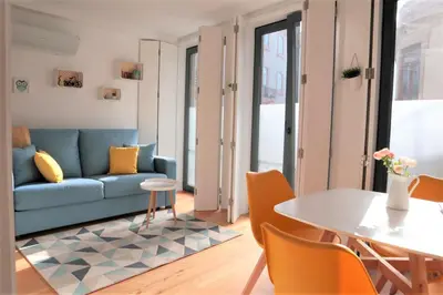 a living room with a blue couch and a table at NEW! Colorful and central (9 min-walk to main station) in Porto